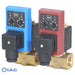Two IAC timer solenoid valves, one blue and one red, mounted on brass manifolds against a white background.